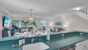 A modern kitchen with a large island, a built-in sink, and a dining area with a view. - Bonefish Bungalow (MARATHON)