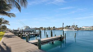 A marina with wooden docks, a white yacht, and a clear blue sky. - Bonefish Bungalow (MARATHON)