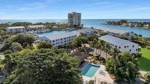A resort with multiple buildings, a marina, and a pool area. - Bonefish Bungalow (MARATHON)