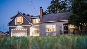 A two-story house with a garage, a chimney, and a porch with chairs. - Coffee Lover`s Loft! Walk to Lake & brews. A/C (Estes Park)