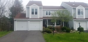 A two-story house with a front garage, a covered porch, and a well-maintained lawn. - Entire House 2 miles from Buttermilk Falls! Sleeps up to 11 and pet friendly! (Ithaca)