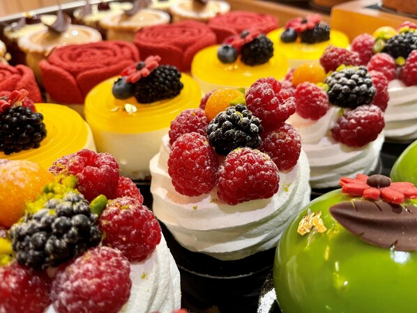 Una variedad de postres cubiertos de frutos rojos y frutas frescas.