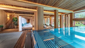 Ein moderner, überdachter Pool mit Holzbalken und einer Glasscheibe.