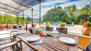 An outdoor dining area with a pool and lounge chairs. - Finca Sa Mina for 12 with pool in Mallorca (Selva)