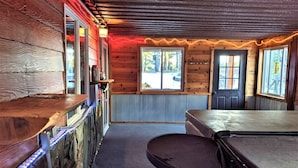 A rustic interior with wooden walls, a bar area, and a view through the windows. - Diamond Jewel - Pool table, Fire Pit (Deadwood)