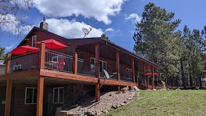A two-story wooden cabin with a balcony, satellite dishes, and red umbrellas. - Diamond Jewel - Pool table, Fire Pit (Deadwood)