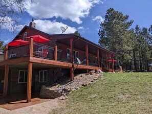 A two-story wooden cabin with a balcony, satellite dishes, and red umbrellas. - Diamond Jewel - Pool table, Fire Pit (Deadwood)