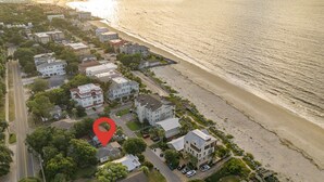 Vista aérea de una zona residencial costera con casas, una playa y una ubicación señalada.