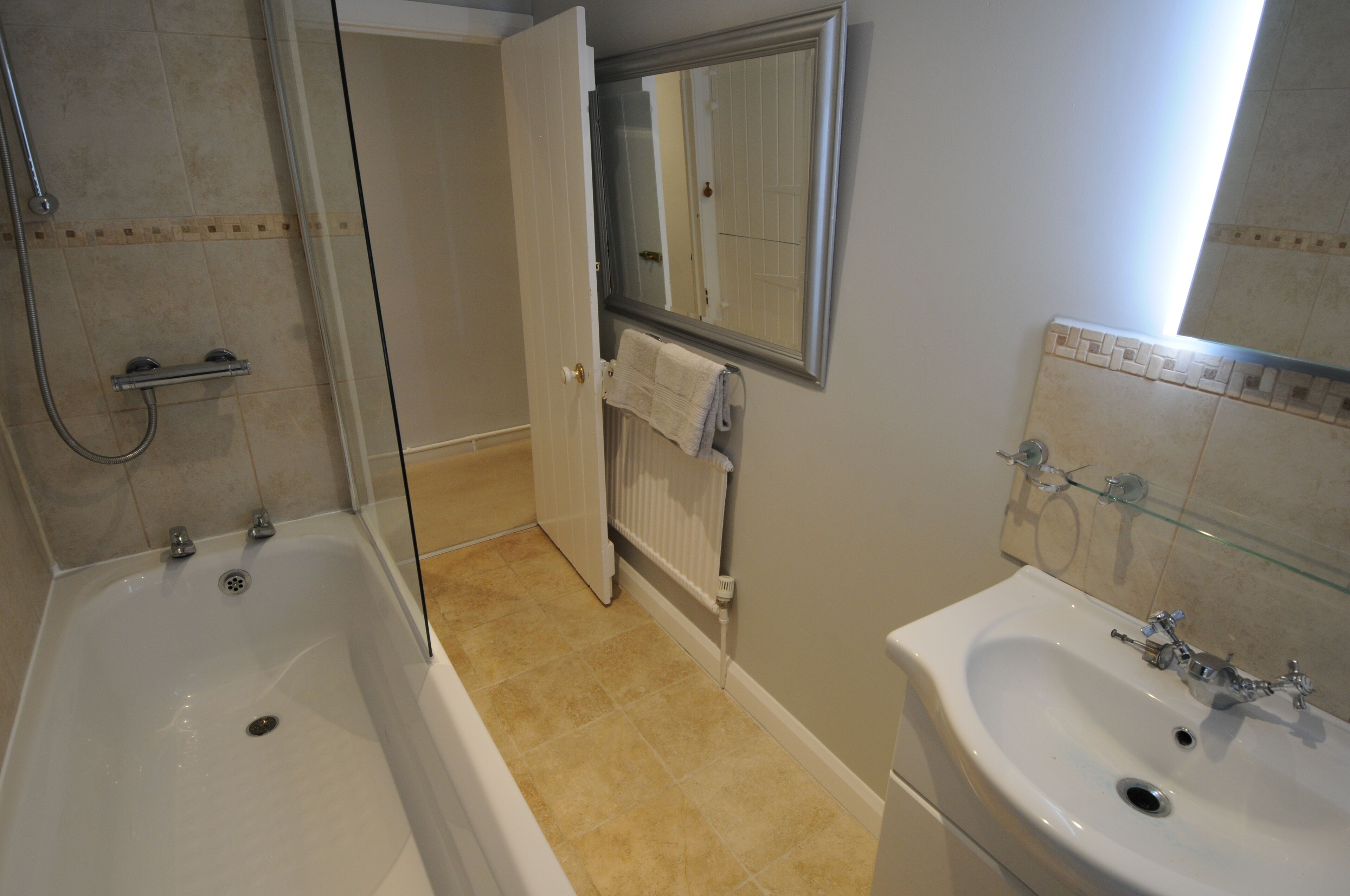 Une salle de bain avec une baignoire, un lavabo, un miroir et une douche.