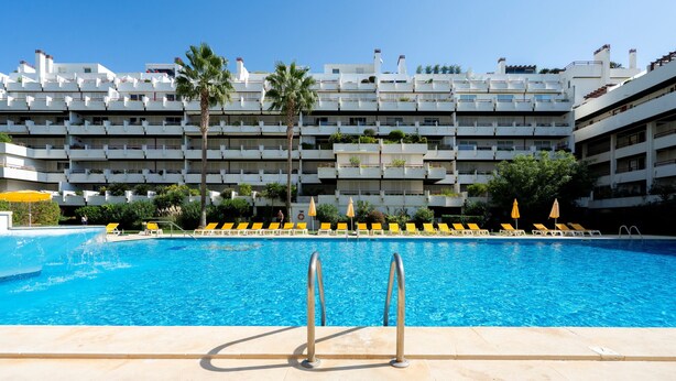 Una piscina con un edificio moderno al fondo.