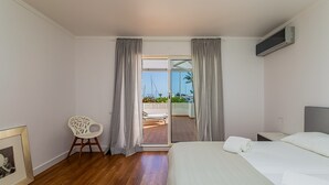 Habitación de hotel con cama, una silla, televisor y vista al exterior.