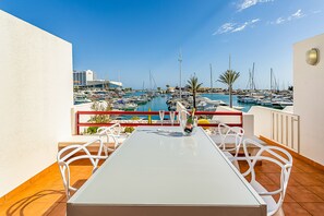 An outdoor dining area with a view of a marina and boats.