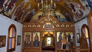 An ornate interior with religious artwork, a chandelier, and a central altar. - Lili Hotel (Malevizi)