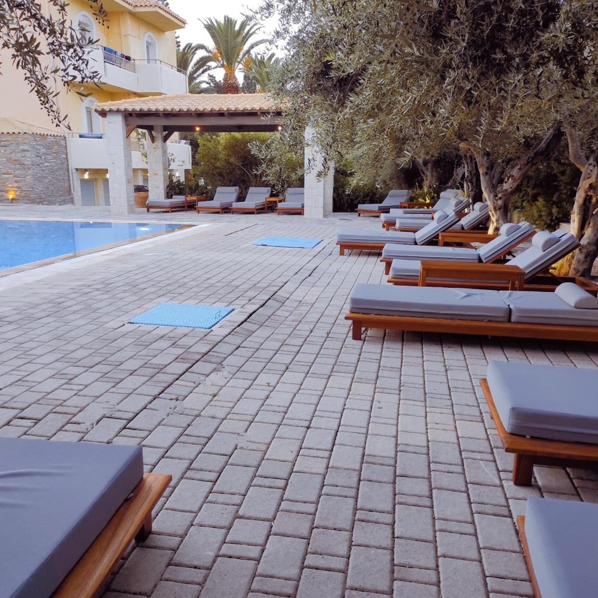 A poolside area with lounge chairs and a pergola.