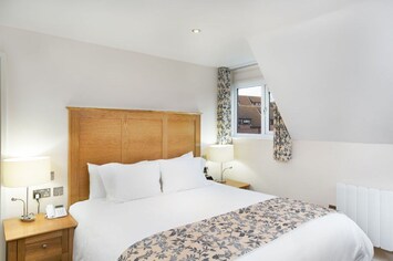 Elegant bedroom with luxurious bedding and charming decor accents.