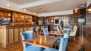 A bar area with wooden paneling, bar stools, and a counter with various bottles.