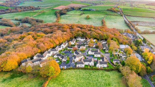Vue aérienne d’un quartier résidentiel avec des maisons, des routes et les champs environnants.