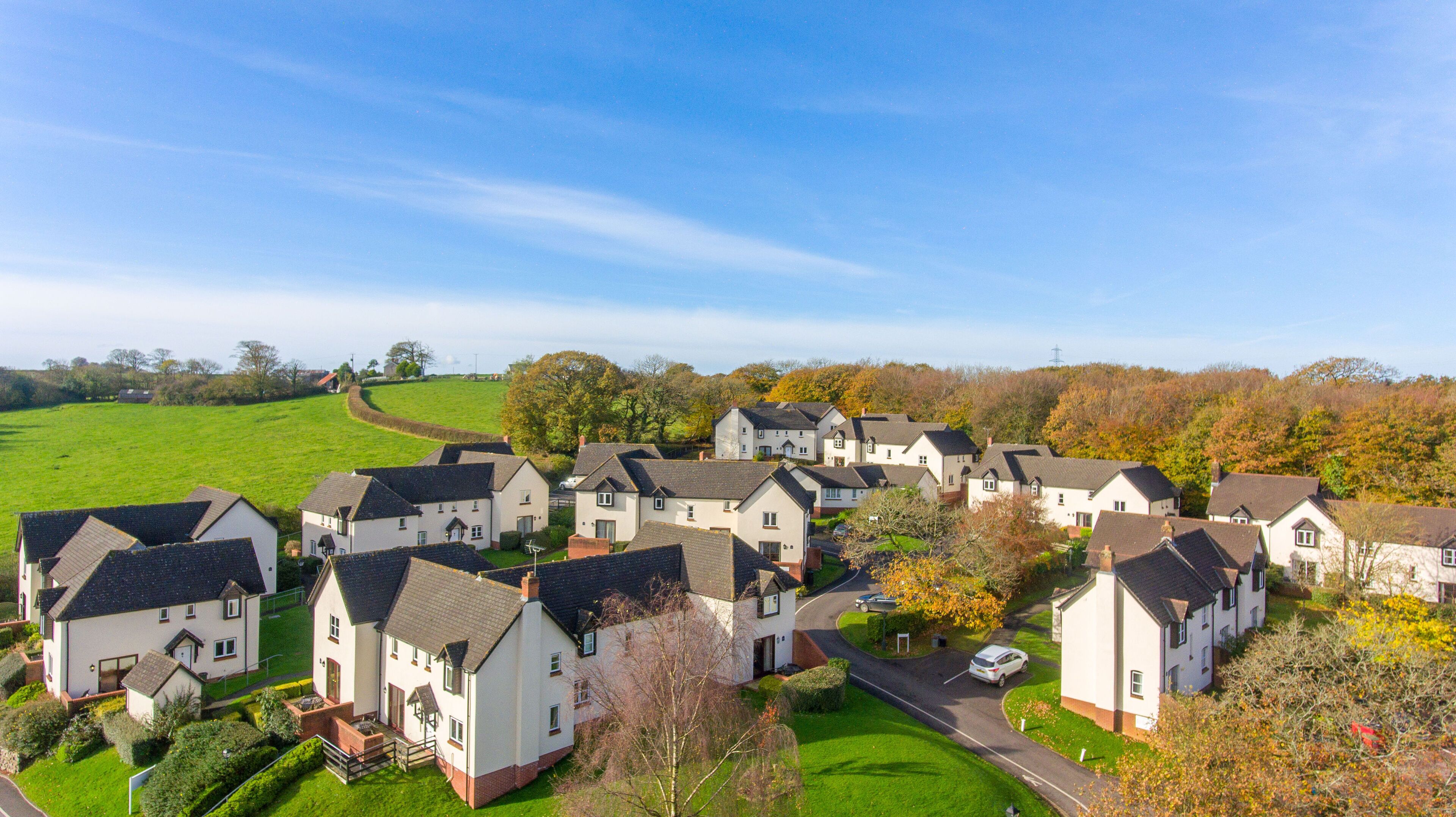 Un quartier résidentiel avec des maisons, un espace vert et une route.