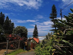 A coastal property with a fenced garden, a small building with a red roof, and a view of the ocean. - All the Tides - Hi Tide (Margate)