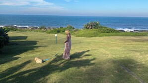 A grassy area with a view of the ocean. - Fisherman's Cottage (Port Edward)