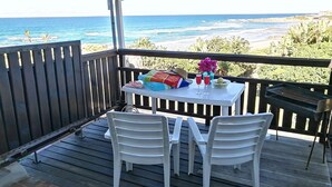 A covered outdoor area with a table and chairs, a grill, and a view of the ocean. - Rosscarbery 5 (Margate)