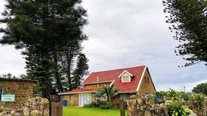 Une petite maison en pierre avec un toit rouge, une porte en pierre et une pancarte indiquant « Whaleback Cottage ».
