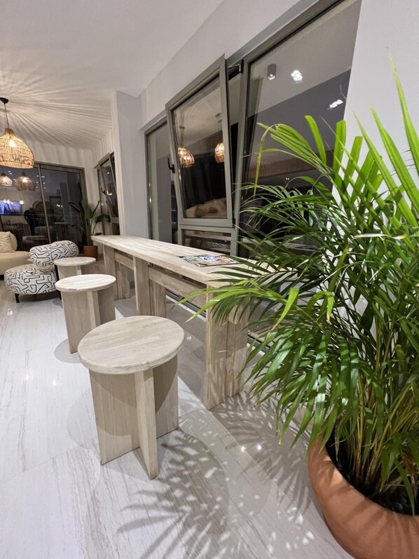 A modern interior with a bar area, seating, and a large potted plant.