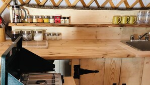 A compact kitchen with wooden cabinets, a built-in stove, and a sink.