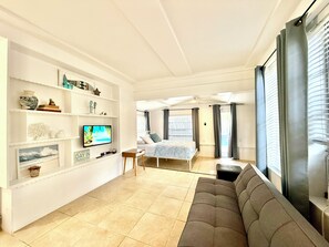 A modern living room with a sofa, a television, and a bookshelf.