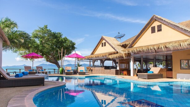 A pool area with lounge chairs, umbrellas, and a view of the ocean. - Adarin Beach Resort (Koh Samui)
