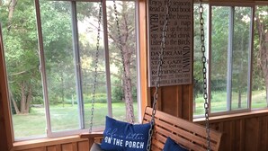 A wooden porch swing with cushions, large windows, and a sign listing porch rules. - Super Spacious Lakehome (Richmond)