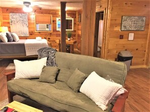 Relax in a stylish room with a green sofa, wooden table, and framed artwork.