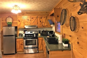 Enjoy cooking in this well-equipped kitchen with a refrigerator, oven, microwave, and sink.