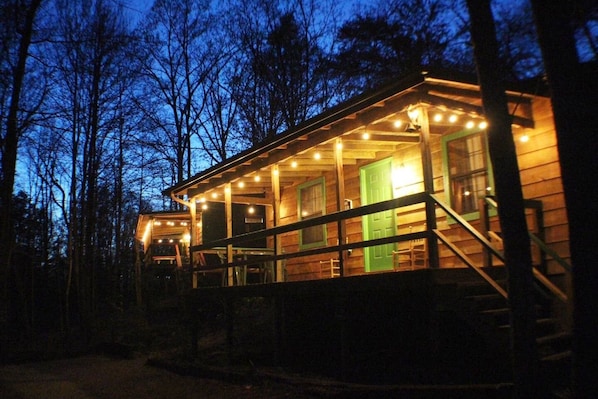 Guests can enjoy a cozy cabin-style retreat with a porch area and a green door.