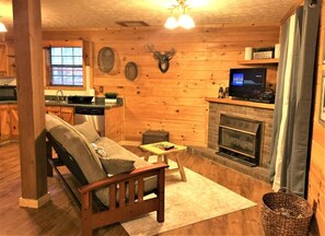 Cozy cabin with a warm ambiance, fireplace, and modern kitchen.
