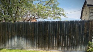 Un hogar circular de ladrillo con una rejilla de metal, rodeado de césped.