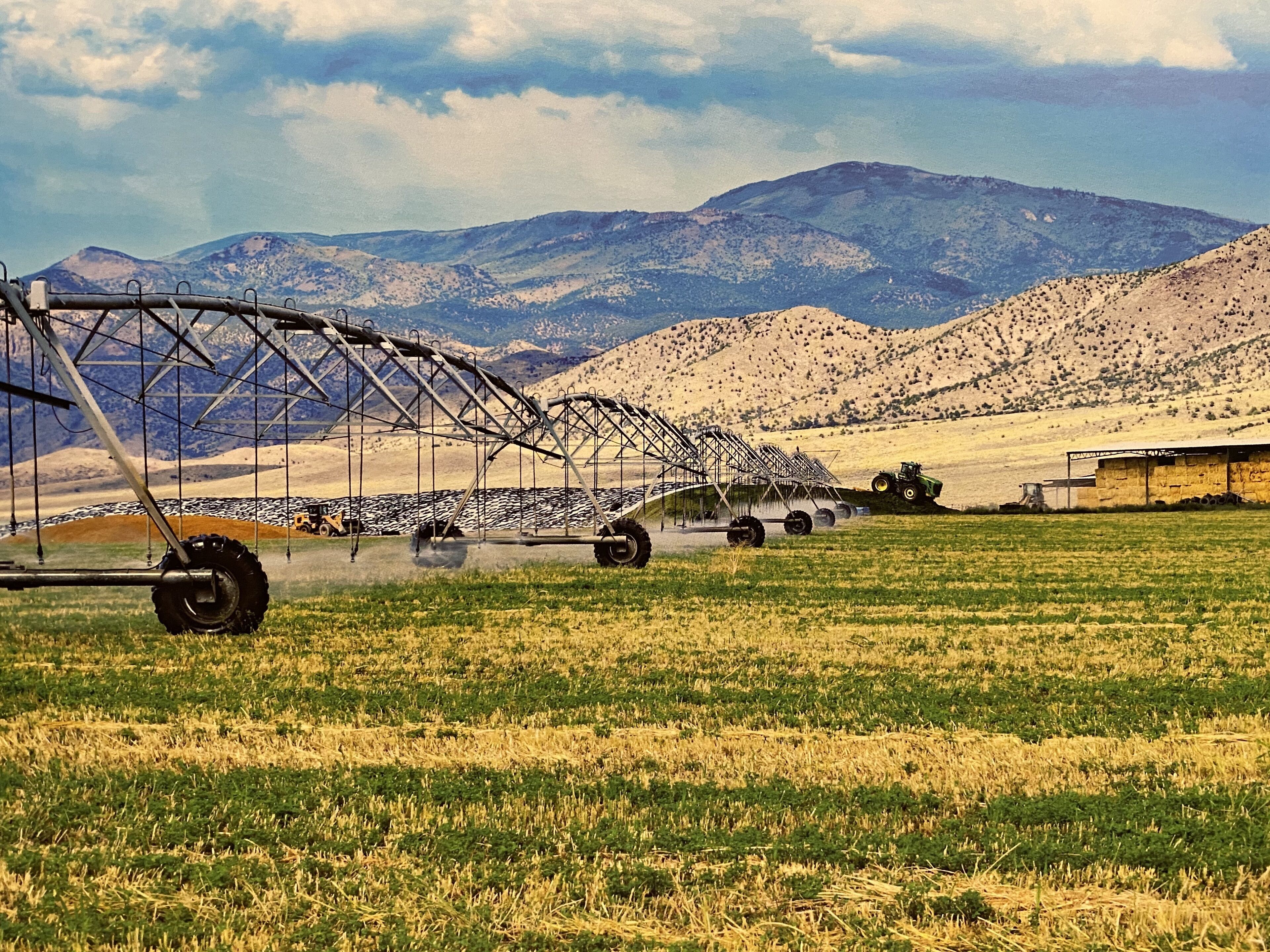 A field with agricultural machinery, a tractor, and a large irrigation system.