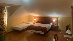 A room with two beds, a desk, and a chair. - Hotel Camino Real (Valdefresno)