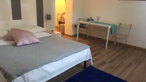 Une chambre à coucher comprenant un lit, une table de chevet et un bureau avec une chaise.