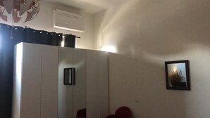 Une pièce avec un grand miroir, un ventilateur de plafond et un petit tableau encadré accroché au mur.