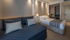 Habitación de hotel con dos camas, un armario y un espejo.