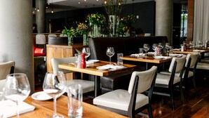 En restaurantindretning med dækketøjsfade, stole og dekorative vaser med blomster.
