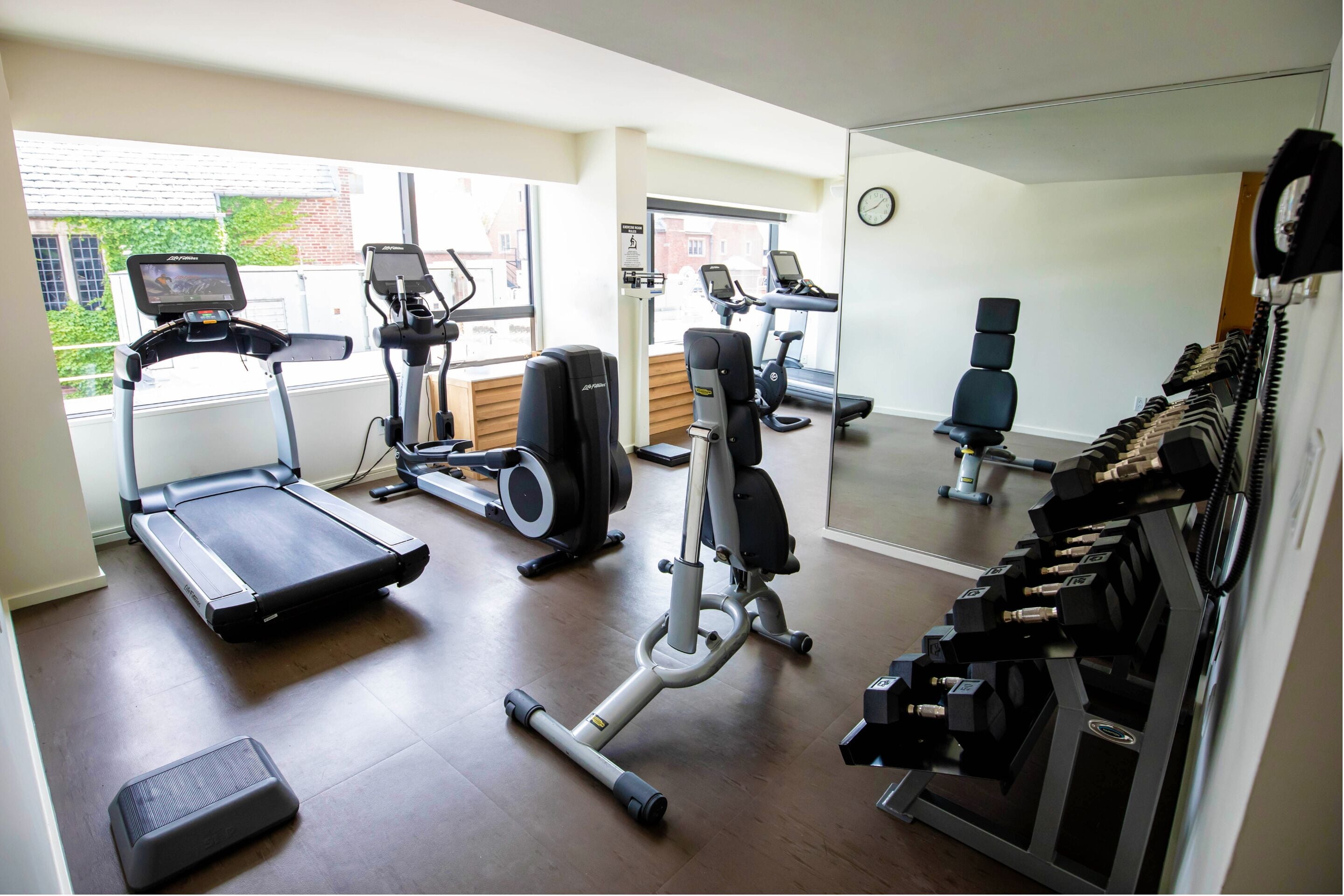 Ein Fitnessstudio mit Laufbändern, Crosstrainern und Kraftgeräten.