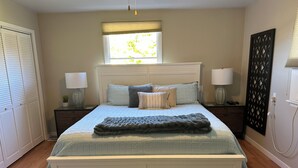 A bedroom with a bed, bedside lamps, a window, and a decorative panel. - Located in the heart of Downtown Saugatuck (Saugatuck)
