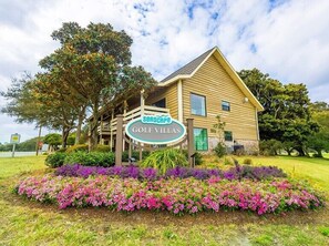 Experience the charm of Searsage Golf Villas, where a gabled roof and covered porch invite relaxation amidst beautifully maintained gardens.