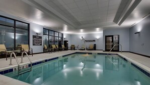 Ein Hallenbad mit klarem Wasser, Tiefenlinien und einem Schild, das darauf hinweist, dass keine Badeaufsicht vorhanden ist.