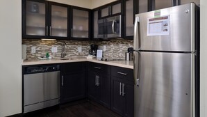 A modern kitchen with dark cabinets, stainless steel appliances, a microwave, and a refrigerator. - King Suite | Free Breakfast + Shared Pool & Hot Tub. Close to Mayo Clinic! (Rochester)