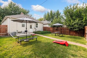 A backyard with a picnic table, a red play structure, and a covered patio area. - Walk to Falls / Close to Everything / Fenced Backyard (Minneapolis)