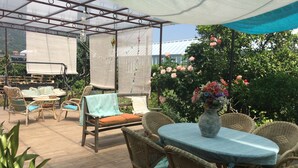 An outdoor patio with wicker furniture, a round table, and a hanging chair. - At 8km from the sea two-story apartment in villa (Cisano Sul Neva)