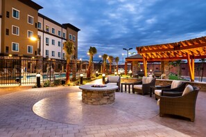 Relax by the fire pit surrounded by lounge chairs and a small pool.